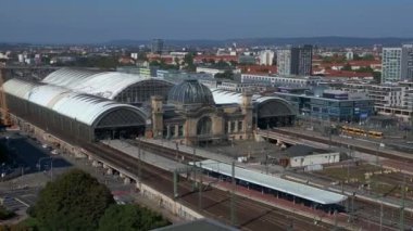 Şehir manzarasındaki Dresden tren istasyonu. Hız rampası hiperlapse hareket hızı zaman aşımı. İHA, açık bir günde şehir binaları arasında genişleyen bir tren istasyonunu çekerken vuruldu.