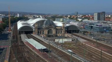 Şehir manzarasındaki Dresden tren istasyonu. Geniş yörüngeli insansız hava aracı. İHA, açık bir günde şehir binaları arasında genişleyen bir tren istasyonunu çekerken vuruldu.
