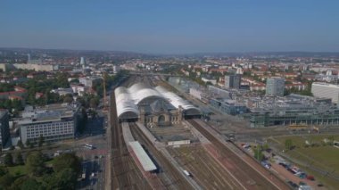 Şehir manzarasındaki Dresden tren istasyonu. Sağ İHA 'ya dön. İHA, açık bir günde şehir binaları arasında genişleyen bir tren istasyonunu çekerken vuruldu.