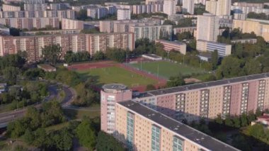 Kentsel spor kompleksi ve yerleşim alanı. İHA 'yı ileri it. Kalabalık bir şehrin yüksek binalarının ortasındaki bir spor sahasının kuş bakışı görüntüsü.