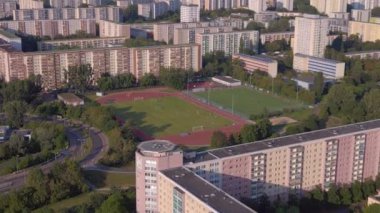 Kentsel spor kompleksi ve yerleşim alanı. İHA 'lar yukarıdan aşağıya bakıyor. Kalabalık bir şehrin yüksek binalarının ortasındaki bir spor sahasının kuş bakışı görüntüsü.