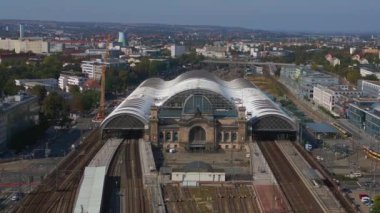 Şehir manzarasındaki Dresden tren istasyonu. Panorama insansız hava aracı. İHA, açık bir günde şehir binaları arasında genişleyen bir tren istasyonunu çekerken vuruldu.