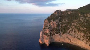 Deniz kenarındaki uçurum, günbatımının sıcacık ışıltısıyla güneşleniyor. Yüksek kalite 4k görüntü
