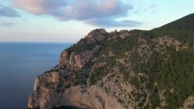 Deniz kenarındaki uçurum, günbatımının sıcacık ışıltısıyla güneşleniyor. Yüksek kalite 4k görüntü