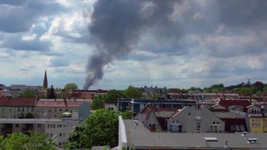Yoğun bir duman bulutunun ters uçan drone 'u bulutlu bir günde Berlin siluetinin üzerinde yükselen büyük bir yangından yükseliyor.