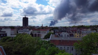 Yoğun bir duman bulutunun İHA 'sı bulutlu bir günde Berlin siluetinin üzerinde büyük bir yangından yükseliyor.