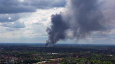 Yoğun bir duman bulutunun üstündeki drone çekimi bulutlu bir günde Berlin ufkunun üzerindeki büyük bir yangından yükseliyor.
