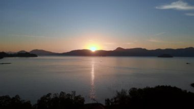 İHA 'yı ileri it. Tranquil gün doğumu. Langkawi adalarının etrafındaki sakin denizin üzerindeki ufku kır.