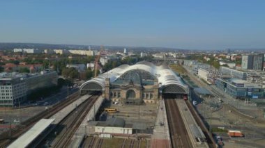 Şehir manzarasındaki Dresden tren istasyonu. Panorama yörünge dronu. İHA, açık bir günde şehir binaları arasında genişleyen bir tren istasyonunu çekerken vuruldu.