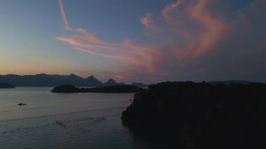 Hız rampası hızlandırılmış zaman aşımı sükunet ve sakin langkawi şafağı okyanus, uzak adalar ve tekneler üzerinde çarpıcı mor renkler, barışçıl ve sakin bir deniz manzarası yaratıyor.