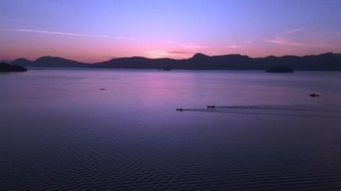 Panorama genel bakış insansız hava aracı Tranquil ve sakin langkawi şafak okyanus, uzak adalar ve tekneler üzerinde çarpıcı mor renkler, barışçıl ve sakin bir deniz manzarası yaratıyor