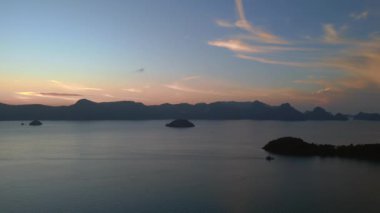 Kuş bakışı dron Tranquil ve sakin langkawi şafak okyanus üzerinde çarpıcı mor renkler, uzak adalar ve tekneler, barışçıl ve sakin bir deniz manzarası yaratıyor
