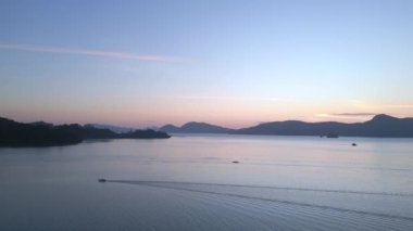 Panorama genel bakış insansız hava aracı Tranquil ve sakin langkawi şafak okyanus, uzak adalar ve tekneler üzerinde çarpıcı mor renkler, barışçıl ve sakin bir deniz manzarası yaratıyor