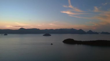 İnsansız hava aracı, Tranquil ve huzurlu langkawi şafağından okyanus, uzak adalar ve tekneler üzerinde çarpıcı mor renkler oluşturarak sakin ve sakin bir deniz manzarası yaratıyor.