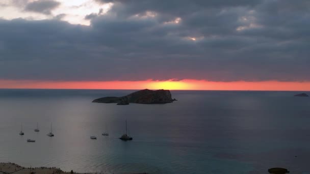 イビサのボートと素晴らしい日没の空を伴うビーチの空中ビュー ドローン降下 — ストック動画