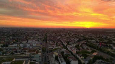 Panorama insansız hava aracı. Gündoğumunda uyanan şehir, canlı turuncu gökyüzü olarak sakin şehir manzarası. Sabahın erken saatlerinde çevre ışığı