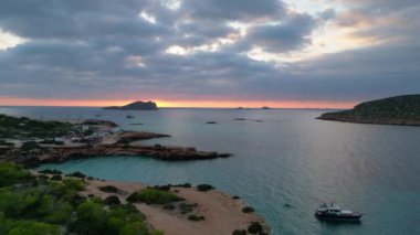 Ibiza 'da tekneli Cala Comte plajı ve çarpıcı bir günbatımı manzarası. hız rampası Hiperlapse hızlandırılmış zaman aşımı 