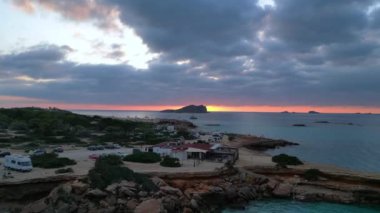 Ibiza 'da tekneli Cala Comte plajı ve çarpıcı bir günbatımı manzarası. Dolly sol İHA 