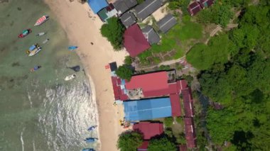 İHA kamerası aşağıya bakıyor. Berrak suları, beyaz kumlu plajları ve yemyeşil yemyeşil yeşiliyle Cennet Kuşu Adası manzarası.