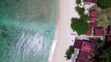 İHA kamerası aşağıya bakıyor. Berrak suları, beyaz kumlu plajları ve yemyeşil yemyeşil yeşiliyle Cennet Kuşu Adası manzarası.