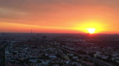 Geri geri uçun. dingin ve sakin şehir manzarasının panoramik görüntüsü canlı turuncu gökyüzü sıcak gökdelenleri ve çatıları yıkıyor.. 