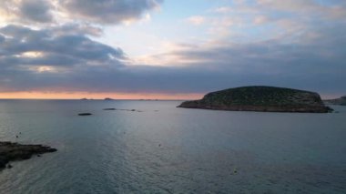 Ibiza 'da tekneli Cala Comte plajı ve çarpıcı bir günbatımı manzarası. Sol İHA 'ya dön 