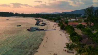 Hız rampası hiperlapse hareket hızı zaman aşımı. Muhteşem bir Tayland plajının üzerinde güneş batıyor, turistler manzaranın tadını çıkarıyor. Turuncu ve altın rengi gökyüzü okyanusa sıcak bir ışık saçıyor. Yaz tatili için mükemmel bir yer.. 