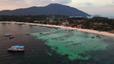 Hız rampası hiperlapse hareket hızı zaman aşımı. Muhteşem bir Tayland plajının üzerinde güneş batıyor, turistler manzaranın tadını çıkarıyor. Turuncu ve altın rengi gökyüzü okyanusa sıcak bir ışık saçıyor. Yaz tatili için mükemmel bir yer.. 
