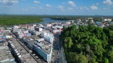 Tayland 'ın güneyindeki Krabi kasabasının hava manzarası arka planda binalar, nehir, deniz ve ormanlı tepelerin karışımını gösteriyor. Uçan İHA 