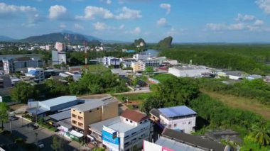 Tayland 'ın güneyindeki Krabi kasabasının hava manzarası arka planda binalar, nehir, deniz ve ormanlı tepelerin karışımını gösteriyor. Ters İHA uçuşu 
