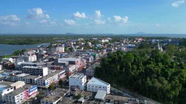 Tayland 'ın güneyindeki Krabi kasabasının hava manzarası arka planda binalar, nehir, deniz ve ormanlı tepelerin karışımını gösteriyor. İHA alçalıyor 