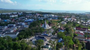 Tayland 'ın güneyindeki Krabi kasabasının hava manzarası arka planda binalar, nehir, deniz ve ormanlı tepelerin karışımını gösteriyor. Ters İHA uçuşu 
