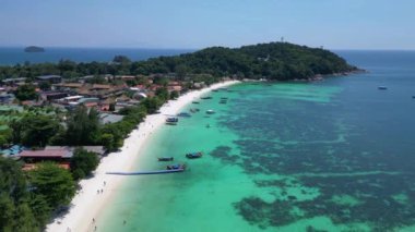 Turistler, turkuaz suya demirlemiş geleneksel Tayland uzun kuyruklu tekneleriyle tropikal bir adada güneşli bir günün tadını çıkarıyorlar. hız rampası Hiperlapse hızlandırılmış zaman aşımı 