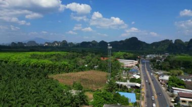 Panorama insansız hava aracı. Bereketli yeşil orman, Tayland, Yengeç 'teki yüksek kireçtaşı dağlarının altındaki vadi tabanını kaplıyor.