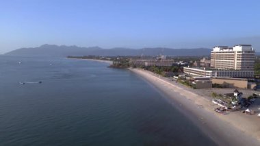 Hız rampası hiperlapse hareket hızı zaman aşımı. Langkawi sahil şeridinin havadan görünüşü, turistlerin berrak mavi suların tadını çıkardığı tropik bir plajdaki otel ve tatil beldelerini gösteriyor.