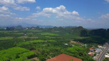 Sağ İHA 'ya dön. Bereketli yeşil orman, Tayland, Yengeç 'teki yüksek kireçtaşı dağlarının altındaki vadi tabanını kaplıyor.