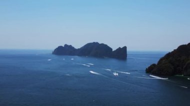 Panorama insansız hava aracı. Sürat tekneleri güneşli bir günde arka planda phi phi leh adasıyla yarışıyor.