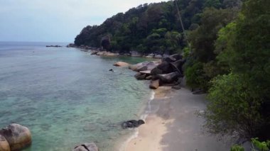 Hız rampası hiperlapse hareket hızı zaman aşımı. Turkuaz okyanus suyu, tropik bir adada yemyeşil bir ormanı olan kayalık bir sahille buluşuyor.