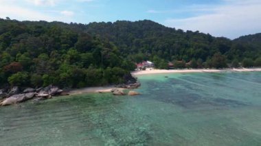 Hız rampası hiperlapse hareket hızı zaman aşımı. Turkuaz okyanus suyu, tropik bir adada yemyeşil bir ormanı olan kayalık bir sahille buluşuyor.