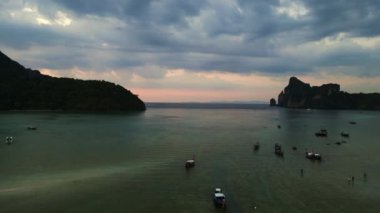 Hız rampası hiperlapse hareket hızı zaman aşımı. Geleneksel uzun kuyruklu tekneler günbatımında sakin sularda yüzerler ve arka planda dramatik bir gökyüzü vardır.