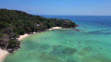 Hız rampası hiperlapse hareket hızı zaman aşımı. Turkuaz suyu olan tropikal bir adanın havadan görünüşü Tayland 'da turistleri bekleyen uzun kuyruk teknelerini gösteriyor.