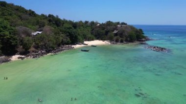 Hız rampası hiperlapse hareket hızı zaman aşımı. Turkuaz suyu olan tropikal bir adanın havadan görünüşü Tayland 'da turistleri bekleyen uzun kuyruk teknelerini gösteriyor.