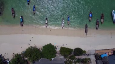 dikey kuşların görüş dronu. Turkuaz suyu, tekneleri, lüks otelleri ve dağlık manzaraları olan phi phi adasının havadan görünüşü