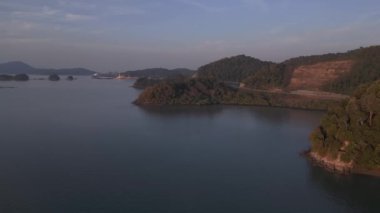 Bereketli yeşil tropikal ada gündoğumunda sakin okyanusla buluşuyor ve arka planda uzak dağlar var. hız rampası Hiperlapse hızlandırılmış zaman aşımı 