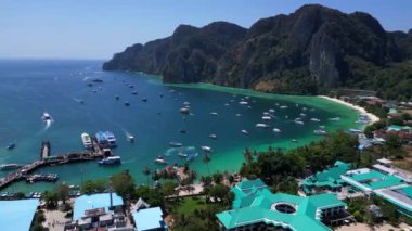 Turkuaz su, tropikal bir adanın kıyılarında nazikçe dolaşırken, arka planda deniz manzarasını noktalayan kayıklar ve yemyeşil tepeler yükseliyor. hız rampası Hiperlapse hızlandırılmış zaman aşımı 