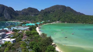 Turkuaz su, tropikal bir adanın kıyılarında nazikçe dolaşırken, arka planda deniz manzarasını noktalayan kayıklar ve yemyeşil tepeler yükseliyor. hız rampası Hiperlapse hızlandırılmış zaman aşımı 