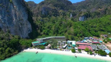 Turkuaz su, doğanın güzelliğini gösteren bir tatil köyü olan tropikal bir adayı çevrelemektedir. İHA yükseliyor 