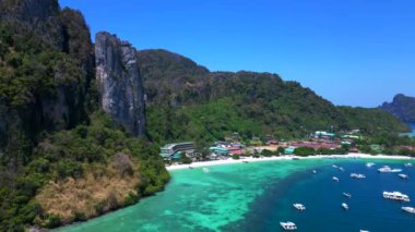 Turkuaz su, doğanın güzelliğini gösteren bir tatil köyü olan tropikal bir adayı çevrelemektedir. İHA alçalıyor 