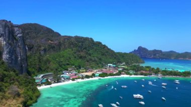 Turkuaz su, doğanın güzelliğini gösteren bir tatil köyü olan tropikal bir adayı çevrelemektedir. Sağ drona döndür 