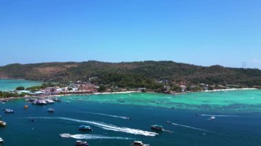 Turkuaz su, doğanın güzelliğini gösteren bir tatil köyü olan tropikal bir adayı çevrelemektedir. Sağ drona döndür 
